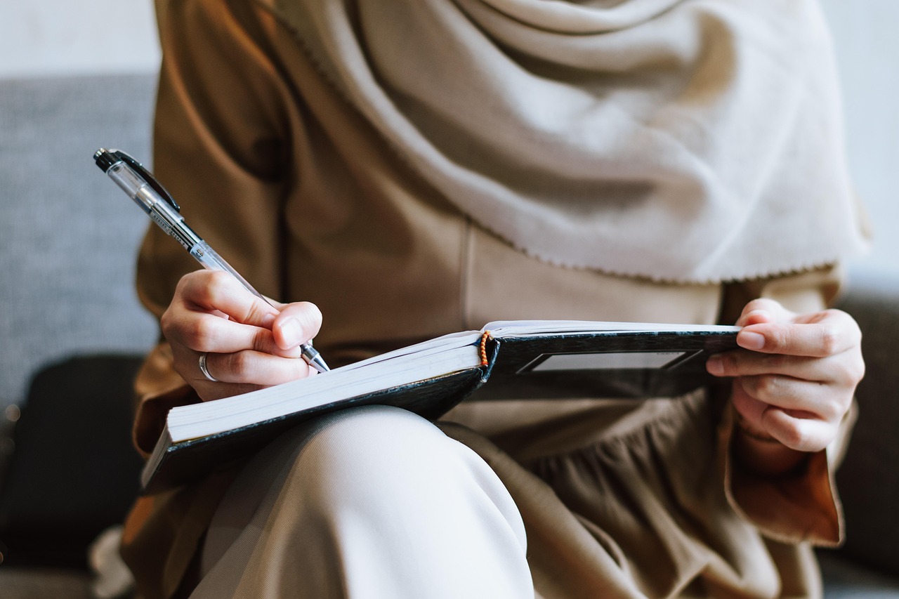 Muslim, woman, writing — Achieve a Natural Looking Boost at Our Miami Breast Augmentation Clinic